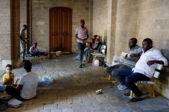 Displaced migrants waiting outside St Joseph's Church in Beirut, earlier today