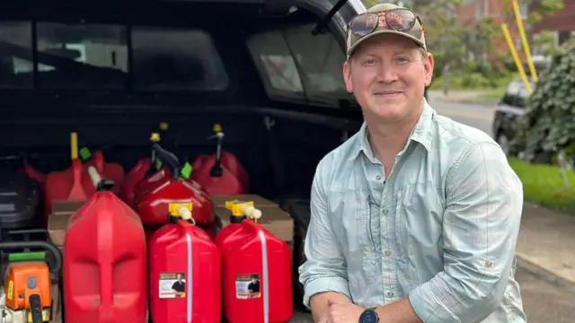 Carey Parker sits next to donated fuel cans