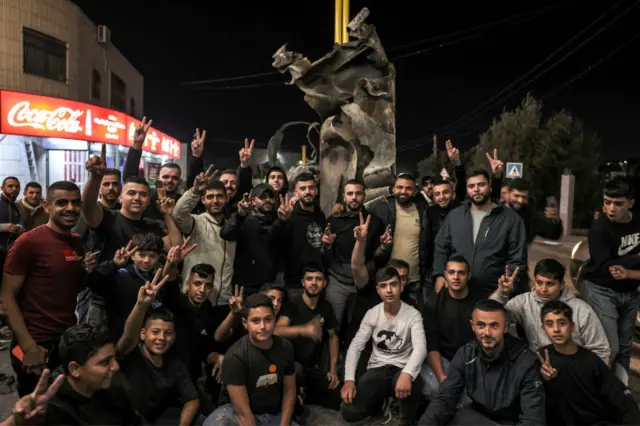 A group poses in front of the rocket