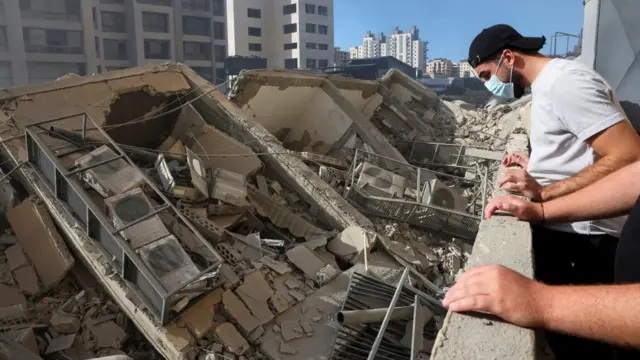 A man looks down on a destroyed building