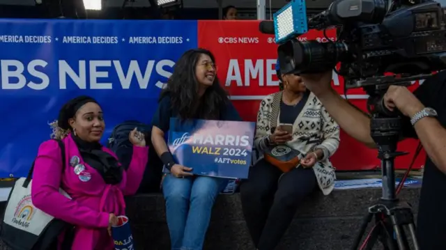 Woman holds Harris Walz sign