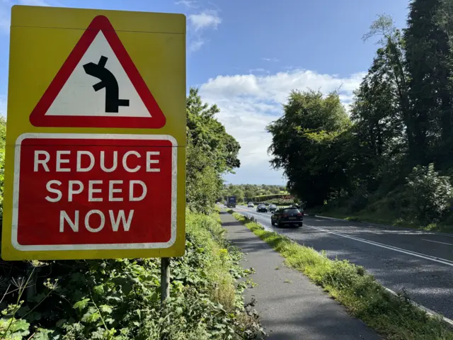 A road sign on the A5 saying reduce speed now