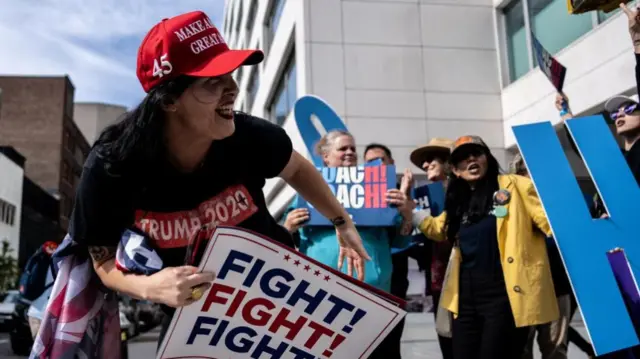 Woman holds "fight fight fight" sign