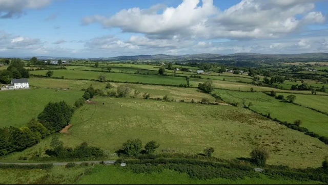 Ariel shot of fields with a few buildings in the background