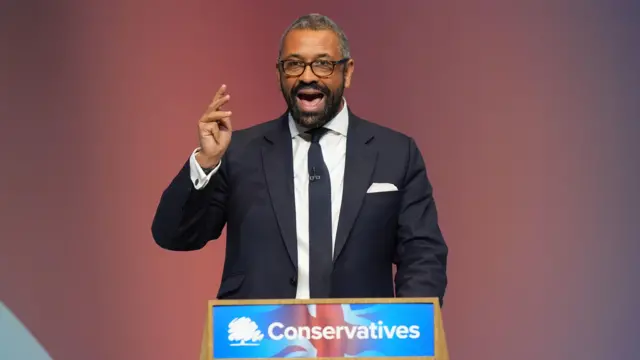 James Cleverly speaking at a lectern