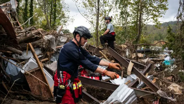 Members of the Illinois Water Rescue One team search through debris for survivors in the aftermath of Hurricane Helene in Swannanoa, North Carolina