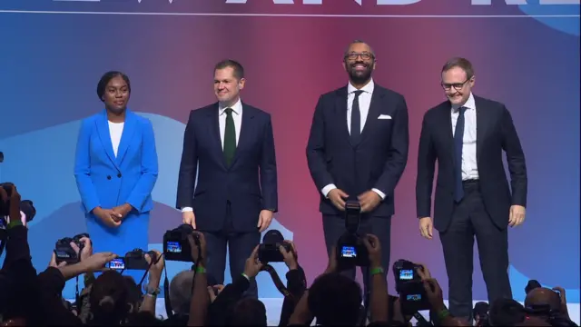 Kemi Badenoch, Robert Jenrick, James Cleverly and Tom Tugendhat on stage as press photographs them on stage