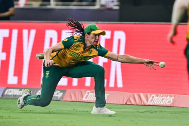 South Africa's Tazmin Brits stretches to stop the ball during the ICC Women's T20 World Cup cricket final match between South Africa and New Zealand at the Dubai International Cricket Stadium