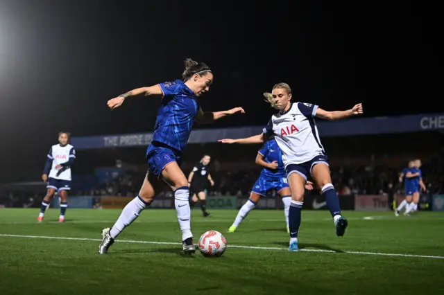 Lucy Bronze of Chelsea runs with the ball whilst under pressure from Amanda Nilden