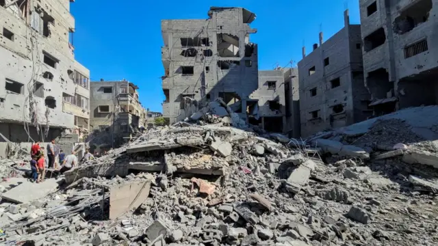Palestinians gather at the site of Israeli strikes on houses and residential buildings in Beit Lahiya