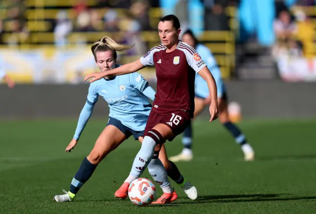 Noelle Maritz of Aston Villa runs with the ball under pressure from Lauren Hemp