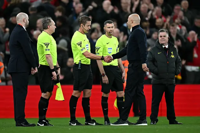 Arne Slot shakes hands with the referee