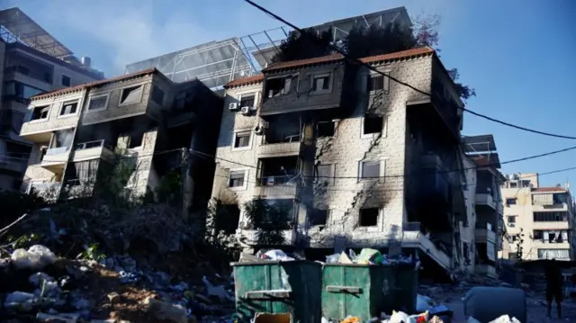 Two residential blocks in Choueifat district in southern suburbs of Beirut with fire damage, and piles of rubbish in the foreground