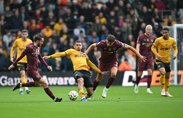 Andre of Wolverhampton Wanderers battles for possession with Bernardo Silva and Ruben Dias