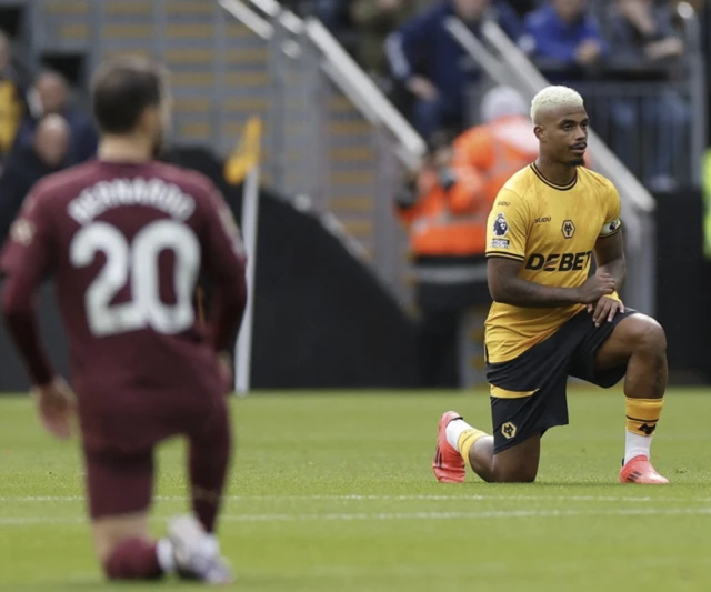 Mario Lemina and Manchester City's Bernardo Silva take a knee