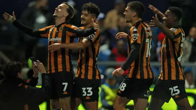 Hull City players celebrate scoring at goal at QPR