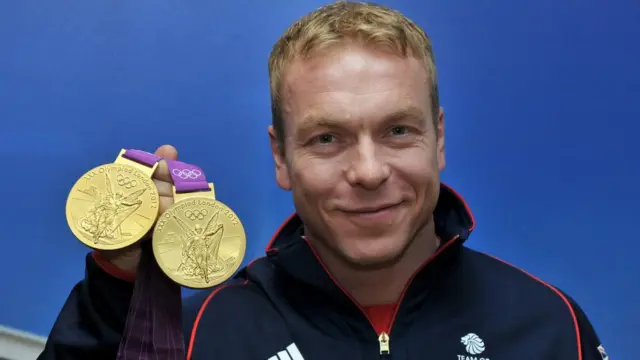 Chris Hoy holding two Olympic gold medals