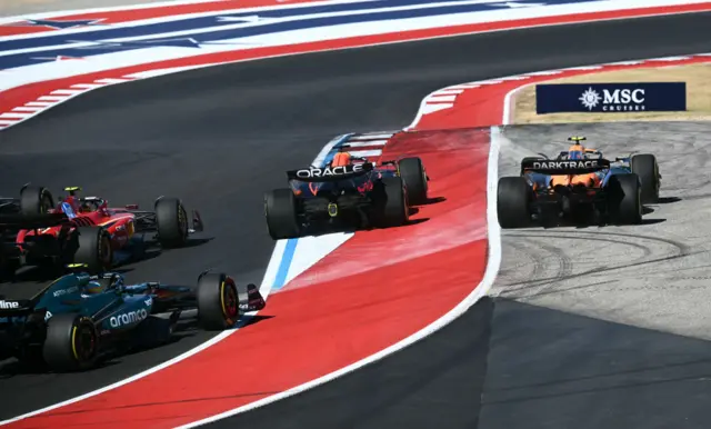 McLaren's British driver Lando Norris (R) goes off track at the start of the United States Formula One Grand Prix