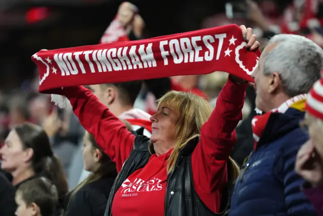 Forest fan holds up a club scarf in the stands