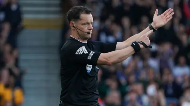 Darren England signals a penalty for handball