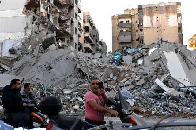 People inspect the site of an Israeli airstrike that targeted a branch of the Al-Qard Al-Hassan finance group in Al-Shiyah, Beirut