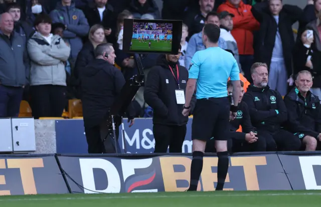 Referee Chris Kavanagh reviews VAR