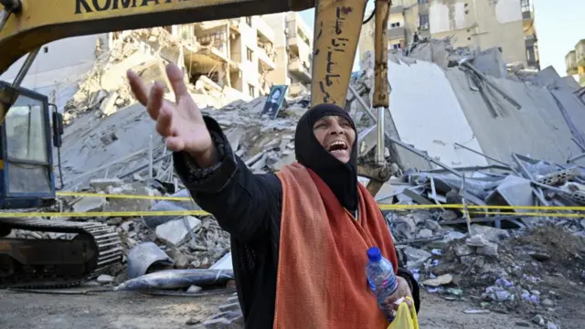 A woman reacts in front of the site of an Israeli airstrike that targeted a branch of the Al Qard al Hassan finance group in Al-Shiyah, Beirut,