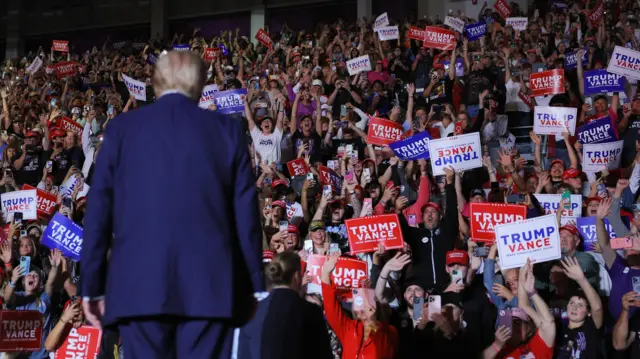 People react as Republican presidential nominee and former US President Donald Trump attends a rally at Williams Arena at Minges Coliseum in Greenville,