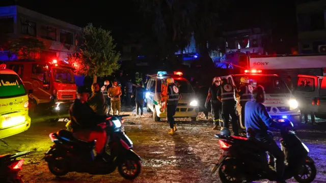 Members of an emergency crew gather at a site near the Rafik Hariri University Hospit