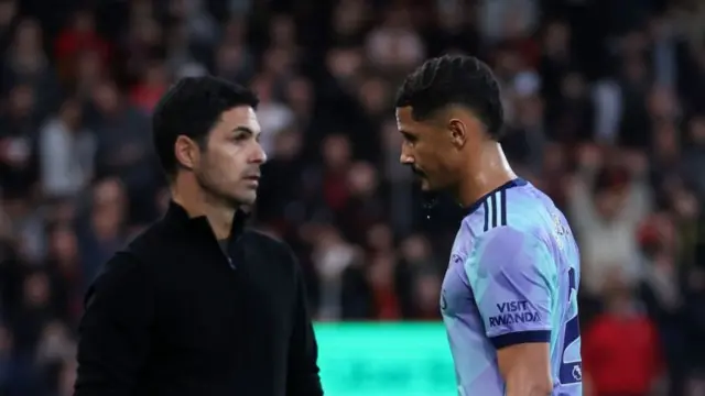 William Saliba walks past manager Mikel Arteta following his sending off against Bournemouth.