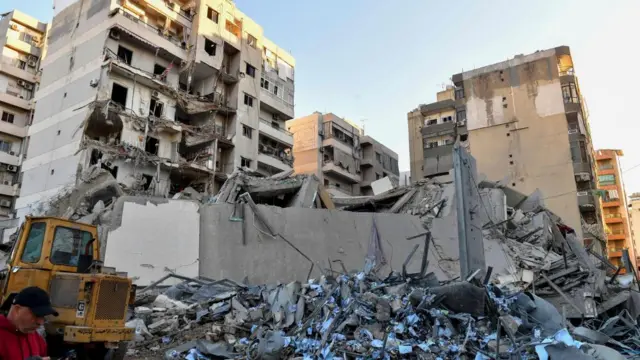 People inspect the site of an Israeli airstrike that targeted a branch of the Al-Qard Al-Hassan finance group in Al-Shiyah, Beirut,