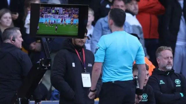 Chris Kavanagh views the VAR monitor in the Wolves v Manchester City game