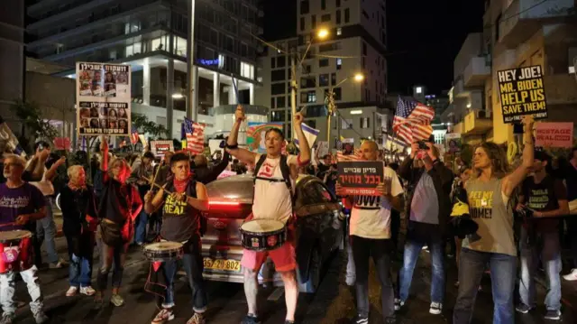 A group of protesters with posters and drums on the street