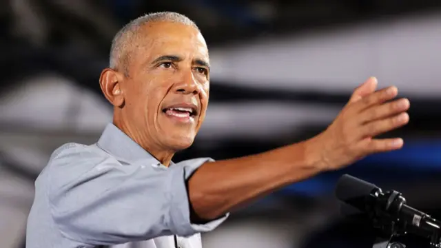 Former US president Barack Obama, wearing a light grey suit, speaks during a rally as he campaigns for Democratic presidential nominee and US Vice President Kamala Harris on the first day of early voting at Cheyenne High School on October 19, 2024 in North Las Vegas, Nevada