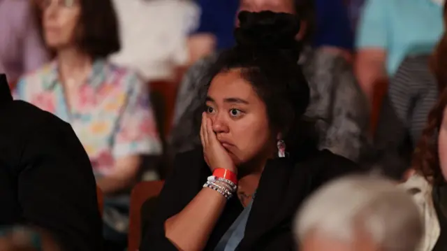 Audience members listen as Democratic presidential nominee U.S. Vice President Kamala Harris speaks at a campaign