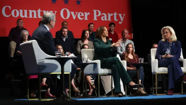 Harris speaking in Brookfield with a sign behind her saying 'country over party'