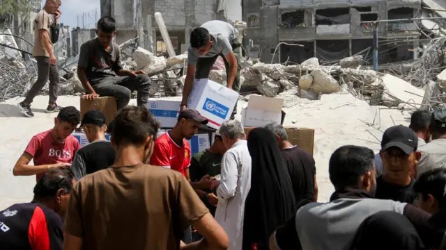 Palestinians gather to receive aid, including food supplies provided by World Food Program (WFP), outside a United Nations distribution center, amid the Israel-Hamas conflict, in Jabalia in the northern Gaza Strip, August 24, 2024