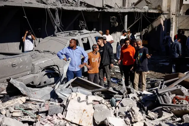 People inspect damage at the site of an Israeli strike near Beirut's Rafik Hariri University Hospital