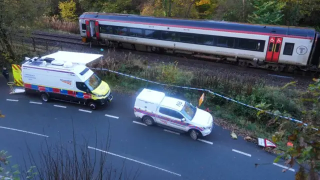 Vehicles are seen on the road alongside the train