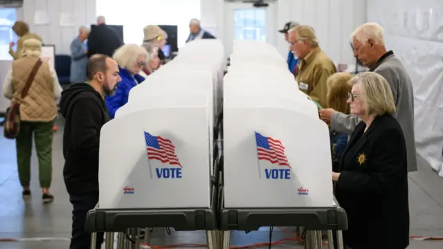 Voters make selections at their voting booths inside an early voting site on October 17, 2024 in Hendersonville, North Carolina