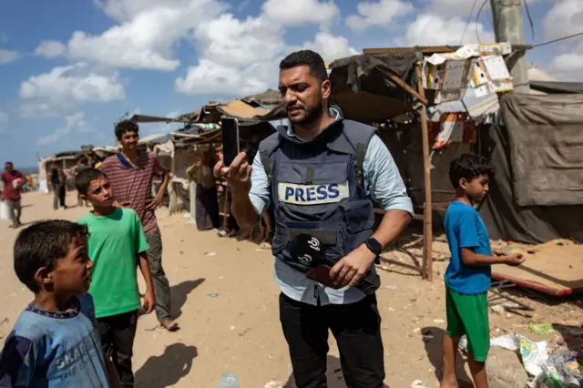 Ghazi Ashraf El-Alloul, a 29-year-old Palestinian journalist, working in a displaced camp in Gaza wearing a Press vest