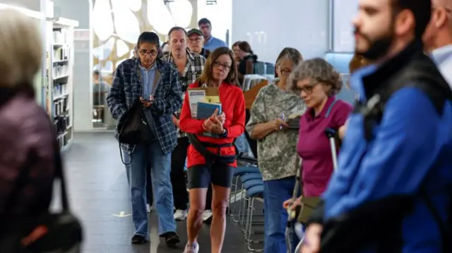 First voters wait in line to cast their votes at an early voting polling location at the Madison Public Library Central in Madison, Wisconsin