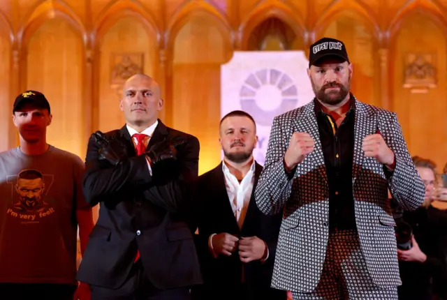 Oleksandr Usyk and Tyson Fury pose for pictures at a news conference