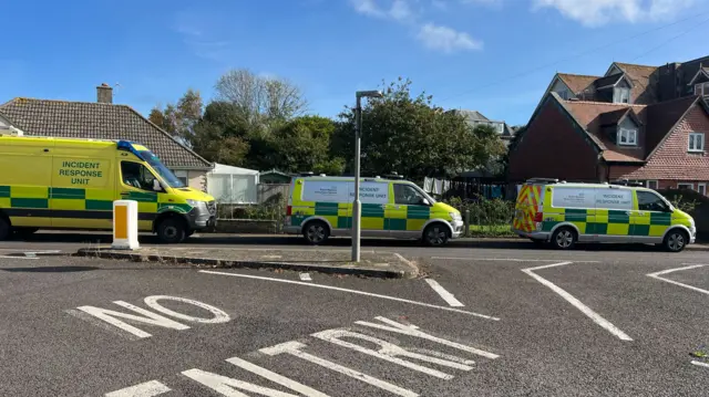 A row of three incident response vehicles lines a residential road