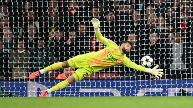 Arsenal goalkeeper David Raya dives to make a save