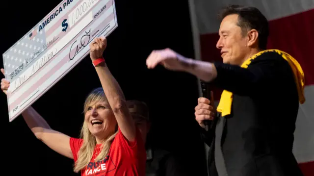 SpaceX and Tesla founder Elon Musk awarded Kristine Fishell with a $1 million check during the town hall at the Roxain Theater on October 20, 2024 in Pittsburgh, Pennsylvania.