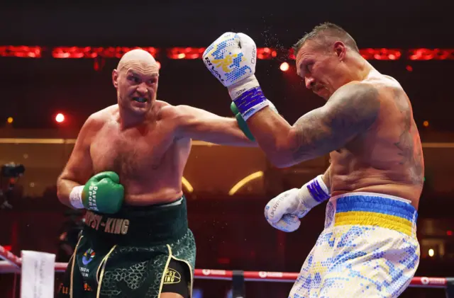 Tyson Fury punches Oleksandr Usyk in the ring