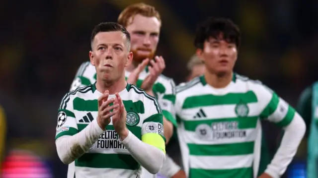 Celtic captain Callum McGregor applauds the accompanying fans