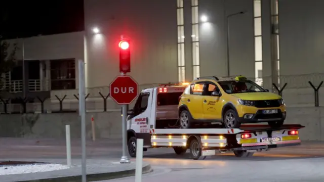 A yellow car, which appears to be a taxi, being towed away