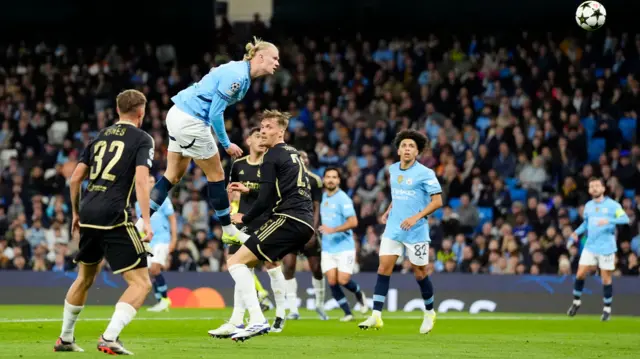 Manchester City's Erling Haaland (top) heads at goal during the UEFA Champions League group stage match at the Etihad Stadium